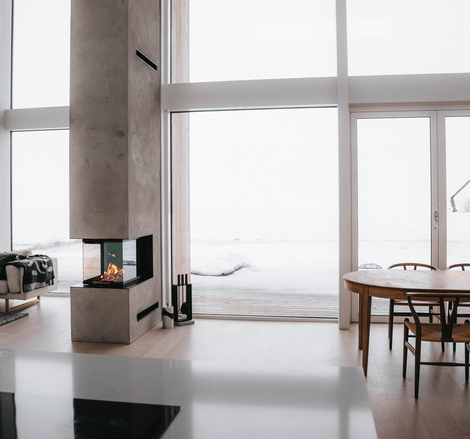 VISIO 3:1 Raumteiler Holz-Kamineinsatz VISIO 3:1 trennt als Raumteiler Esszimmer und Wohnzimmer in einem modernen Haus im Norden