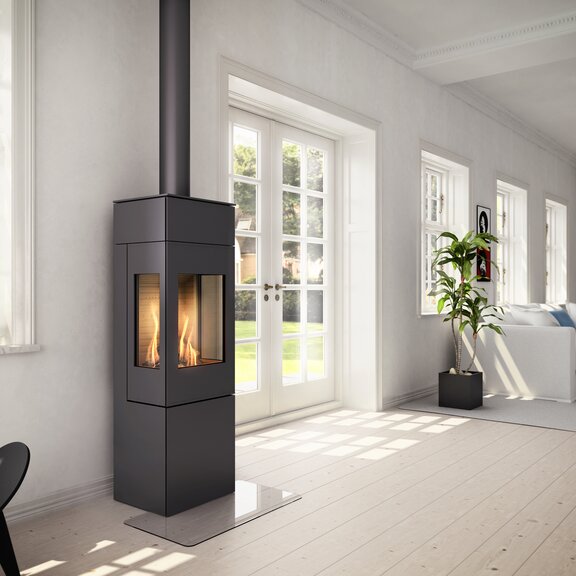 Poêle à gaz NEXO 140 en noir avec porte en acier et deux vitres latérales dans un salon lumineux