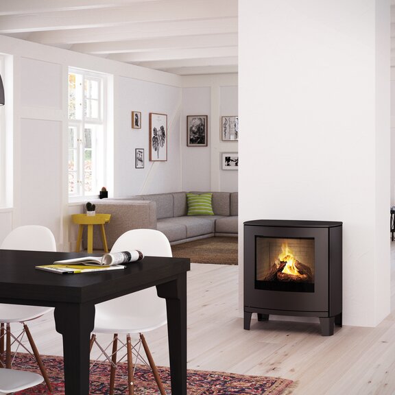 Poêle à gaz Q-TEE 2 C avec porte en acier sur pieds design modernes dans une salle à manger décorative