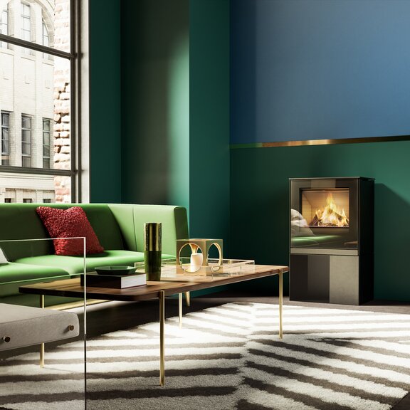 Poêle à gaz Q-TEE 2 avec porte de foyer plein verre et un socle dans un appartement urbain à la décoration raffinée dans les tons émeraude