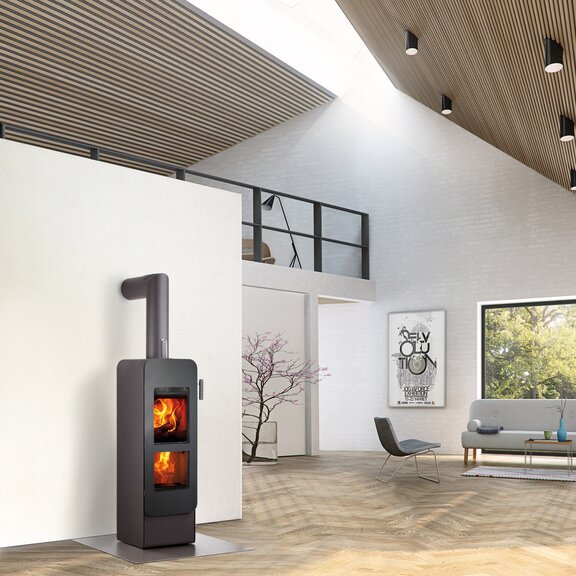 Poêle à bois bionic fire EVO de couleur noire avec porte en acier dans un loft moderne