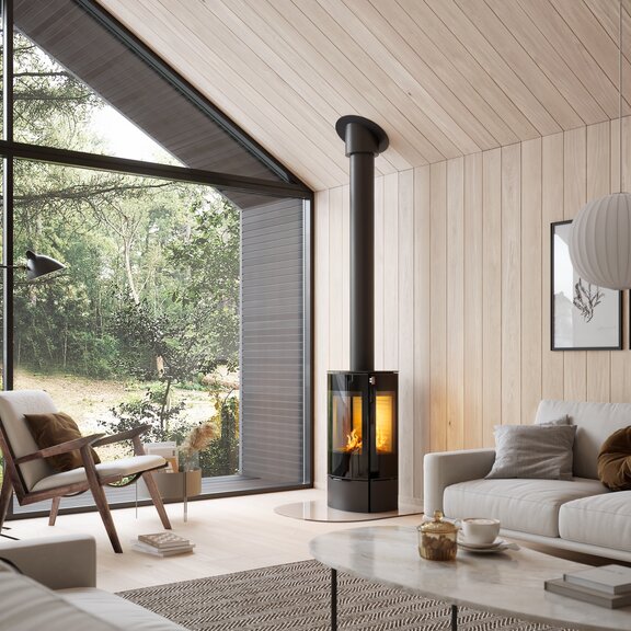 Poêle à bois CARO 90 en noir avec porte de foyer plein verre et vitre latérale dans un salon naturel en beige