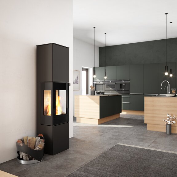 Poêle à bois NEXO 185 en noir avec porte de foyer plein verre et deux vitres latérales au centre de la cuisine et du salon
